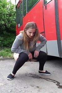 Big-breasted Brunette Taking A Leek Behind A Bus