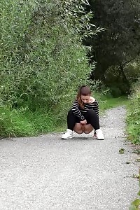 Attractive European Squatting To Piss On A Path